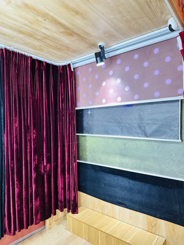 Interchangeable roller backdrops inside a custom photo booth room