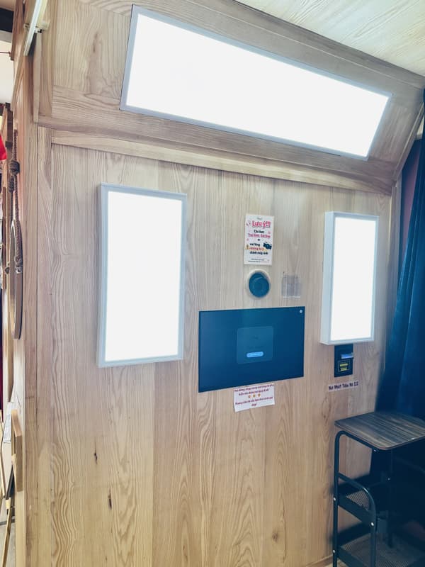 Touchscreen control panel and camera lens built into a solid wood photo booth console